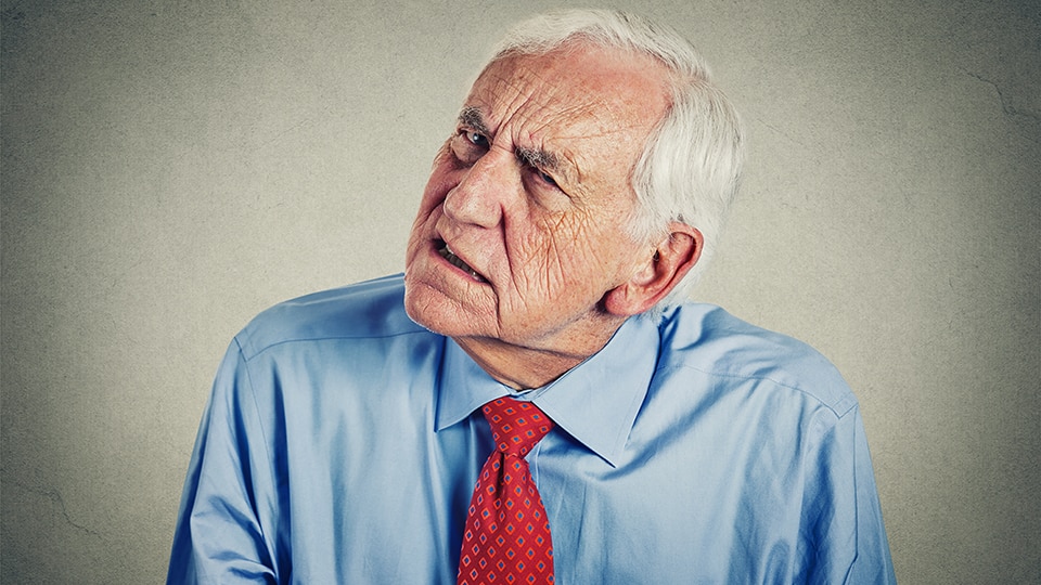 Closeup portrait headshot senior man hard of hearing asking someone to speak up can't hear isolated gray wall background.