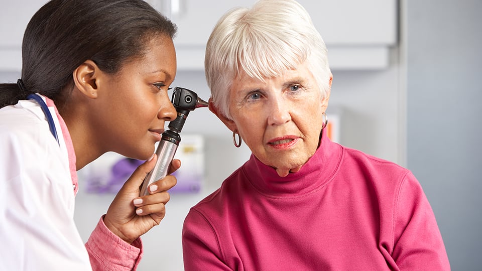 Audiologist Examining Senior Female Patient's Ears